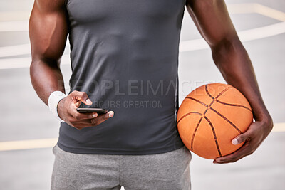 Buy stock photo Closeup of a basketball player texting on a phone while taking a break from playing a match on a sports court outside. Hands of one male athlete browsing social media online during a game interval