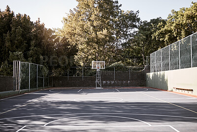 Buy stock photo An empty still life of a basketball court on a sunny day with white marking with a hoop and net. A sports ground or court on a club venue for active practices training and outdoor leisure activities