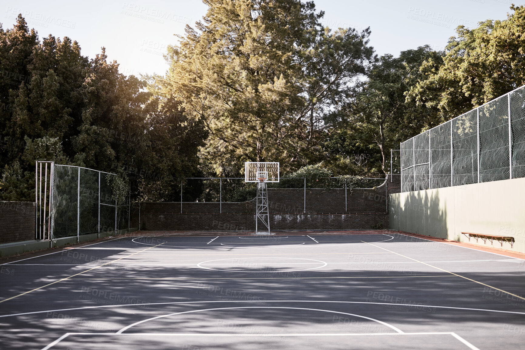 Buy stock photo An empty still life of a basketball court on a sunny day with white marking with a hoop and net. A sports ground or court on a club venue for active practices training and outdoor leisure activities