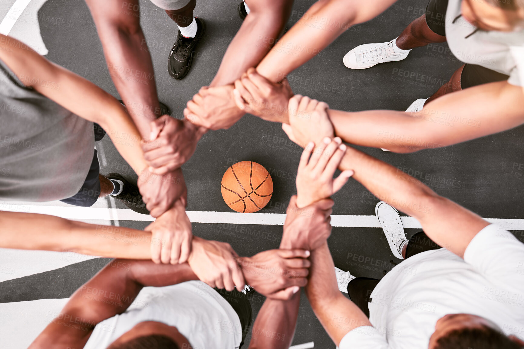 Buy stock photo Athletes showing trust and standing united. Men expressing team spirit with their hands joined huddling at a basketball game. Sportsmen holding wrists in huddle for support and unity at sports match.