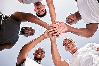 Portrait of diverse group of sporty men from below stacking hands in pile huddle for team support, collaboration and unity. Cheerful motivated athletes huddled in circle for encouraging sport pep talk