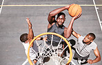 Basketball players from above blocking a player from dunking a ball into net to score points during a match on sports court. Fit athletes jumping to defend in competitive game for recreational fun
