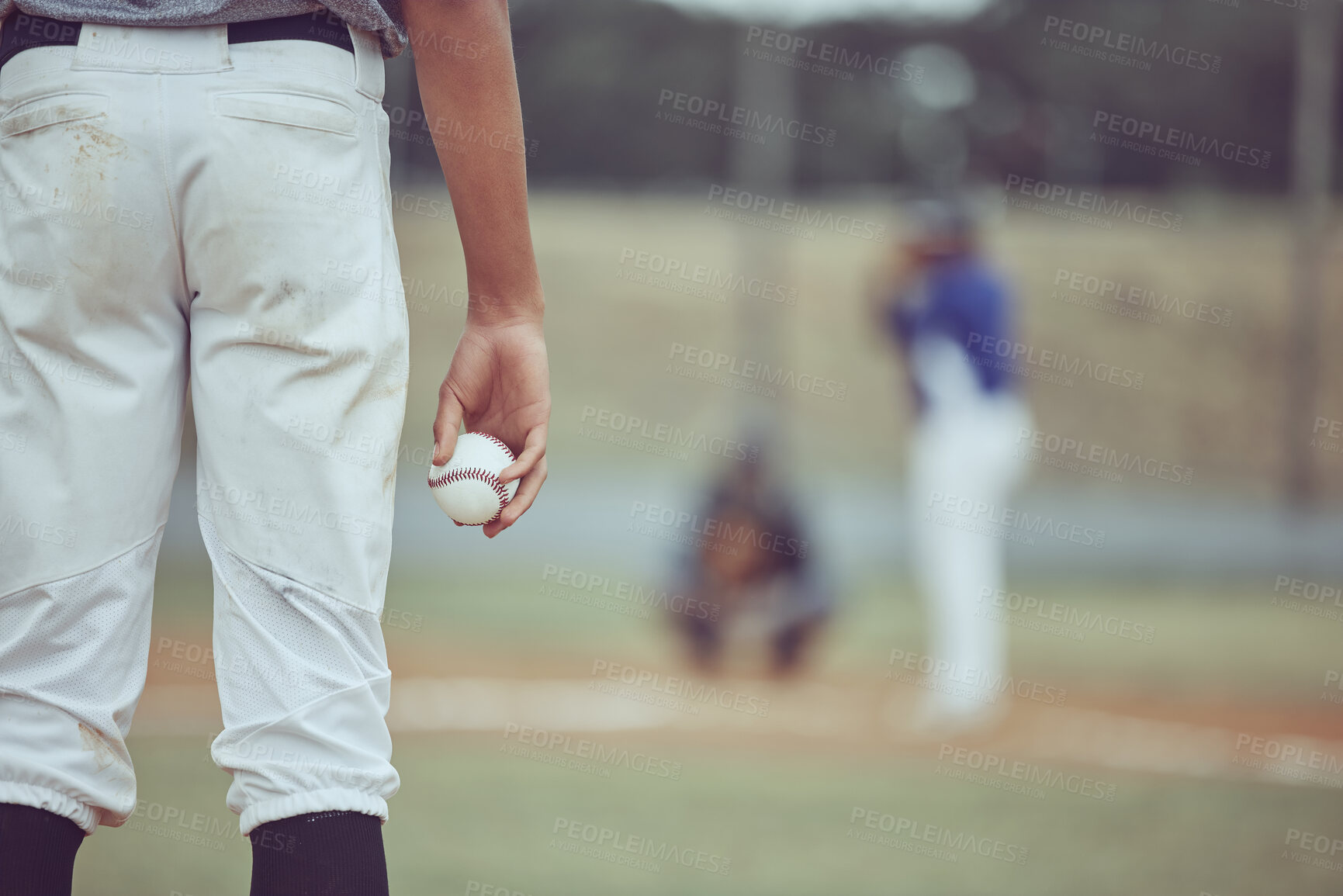 Buy stock photo Baseball player holding ball during a game on the field. Man concentrating before throwing a ball at a sports match. Professional athlete getting ready to throw the ball during a competitive game. 