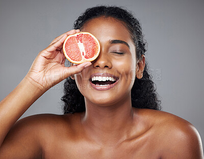 Buy stock photo Beauty, skincare and woman with grapefruit for health, cleaning and grooming in a studio against a grey background. Face, wellness and relax for skin, body and hygiene treatment with black model 