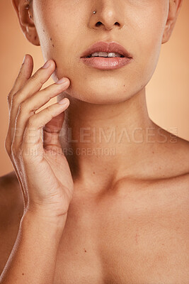 Buy stock photo Hand, face and beauty with a model woman closeup in studio on a beige background for natural skincare. Wellness, luxury and cosmetics with a young female posing to promote a dermatology skin product