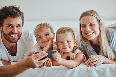 Buy stock photo Happy, family and relax with phone on the bed in fun entertainment streaming together at home. Mother, father and children relaxing in the bedroom with smile for online shows on smartphone indoors