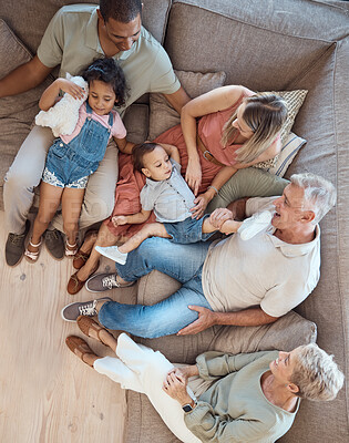 Buy stock photo Family relax, generations and love in home with happy parents, grandparents and children on sofa bonding in overhead. Happy family, together and spending quality time with smile in living room.