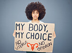 Black woman afro, protest and poster for human rights, female choice or decision against a studio background. Portrait of African American female taking a stand holding cardboard sign for empowerment