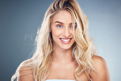 Buy stock photo Skincare, makeup and woman with a smile for hair care, wellness and beauty against a grey studio background. Smile, happy and portrait of a young blonde model for cosmetics and health of body
