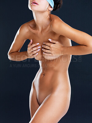 Buy stock photo Studio shot of an attractive naked model pressing her breasts together while wearing a blue blindfold