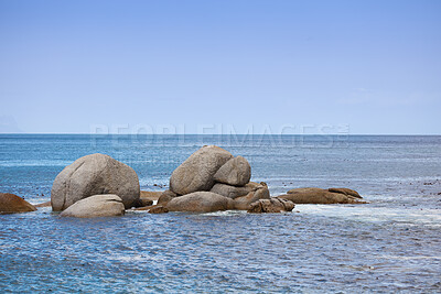 Buy stock photo Copy space, sea rocks and ocean view of calm, serene and peaceful beach with blue sky, waves and copyspace. Relaxing, tropical and remote seascape with boulders on a secluded coastal island in summer