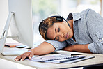 Tired, burnout and sleeping woman at the office. Close up of young exhausted mixed race businesswomen resting on the desk as call center agent in an office. Female taking a nap in the workplace.
