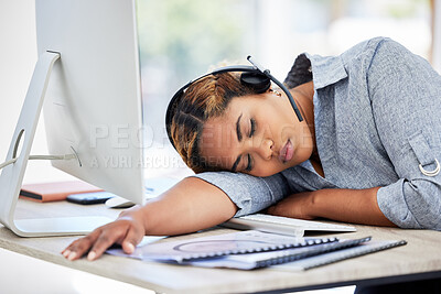 Buy stock photo Tired, sleeping call center agent at the office in the afternoon. Exhausted young businesswomen resting on the desk in an office. Female feeling burnout taking a nap in the workplace.