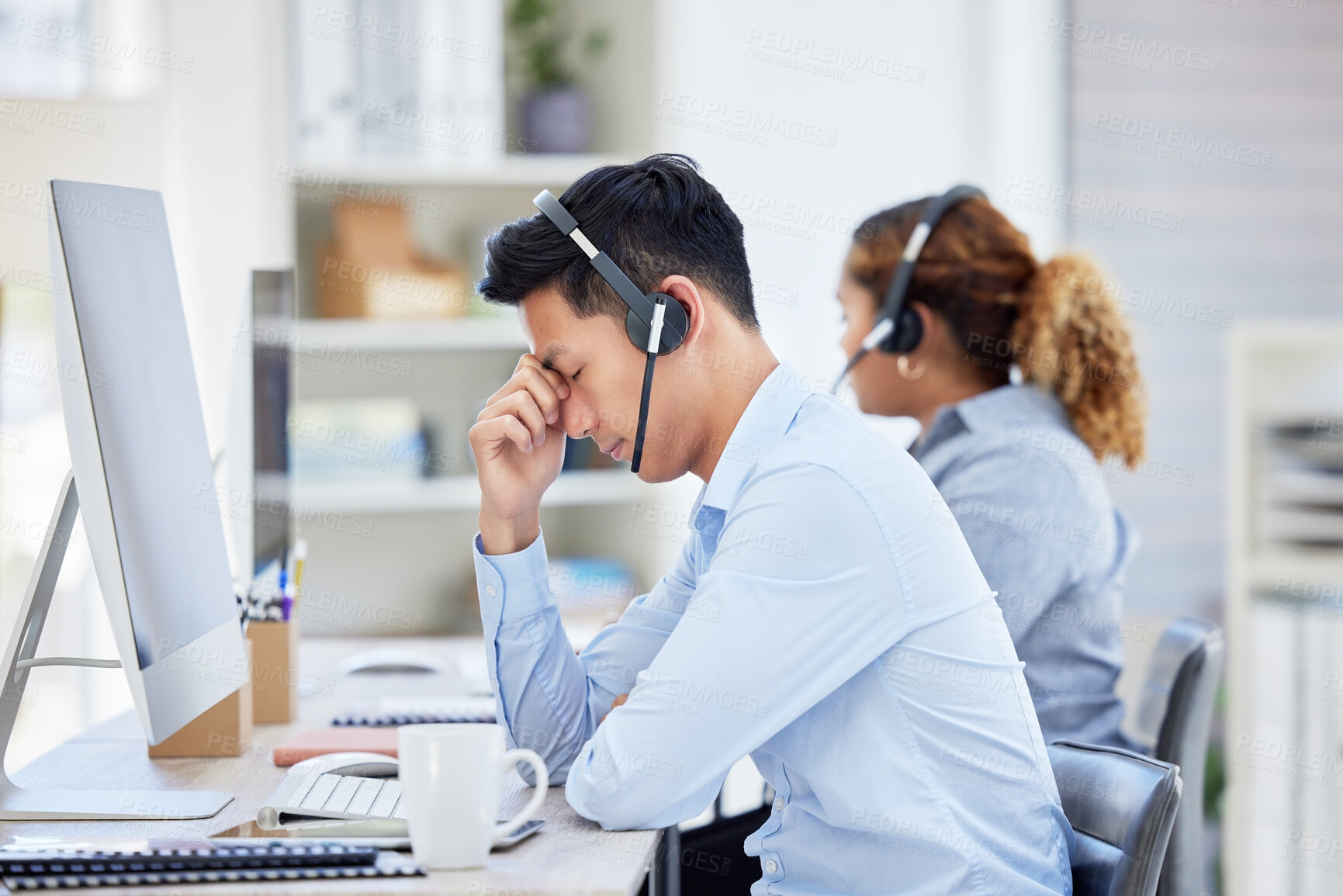 Buy stock photo Annoyed, frustrated and stressed call center agent with a headache and working in customer service. Male IT support assistant struggling with a migraine, feeling angry, upset and irritated