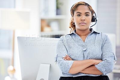 Serious female customer service worker with headphones at the office at a call center. Portrait of a head tech support agent dedicated to helping customers. Closeup of a woman standing at a desk