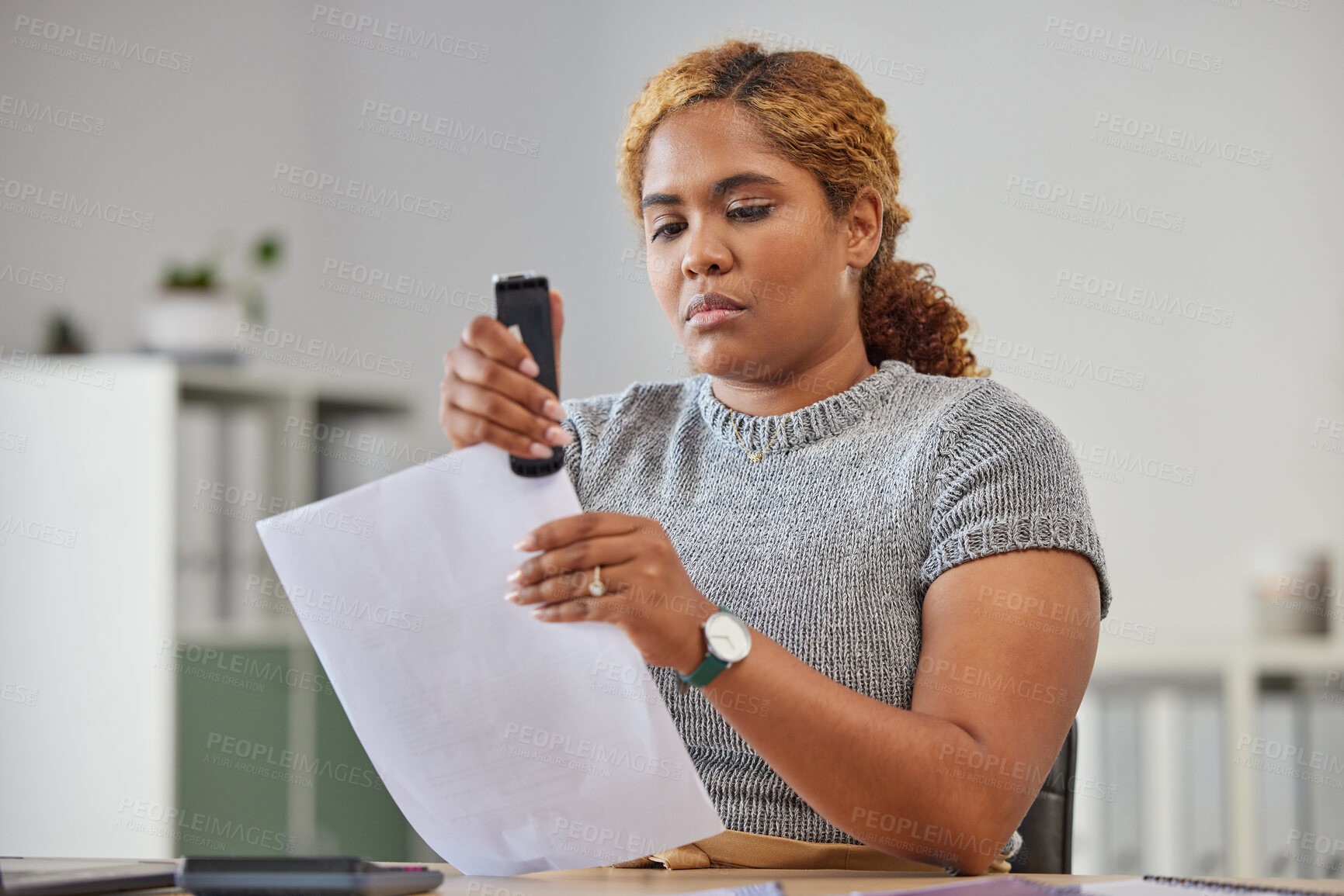 Buy stock photo Female office worker stapling paper together in her office at work, being efficient, organized and neat. Young female admin clerk sorting and filing paperwork while sitting and working at her desk