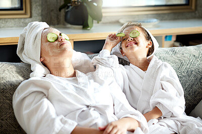 Buy stock photo Fresh skincare, face mask and healthy skin treatment for bonding mother and daughter home spa day. Fun, smiling and playful child and parent relaxing with cucumber over their eyes in grooming routine