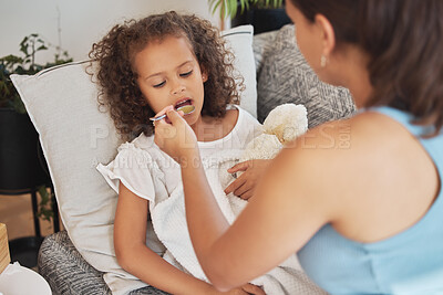 Buy stock photo Sick child drinking medicine, soup or food lying on the sofa for health and recovery inside their home. Ill girl being fed from a spoon by caring, loving and affectionate mother feeding her