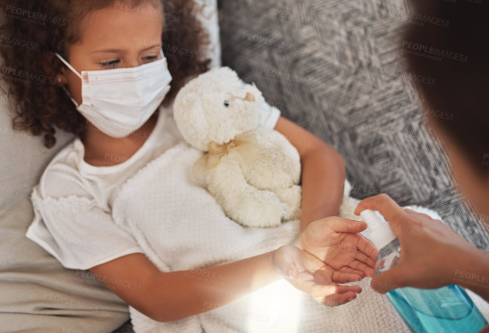 Buy stock photo Cleaning hands with sanitizer during covid, caring mother showing good hygiene habits for sick child. Close up of a parent taking care of an unwell daughter during the coronavirus pandemic.