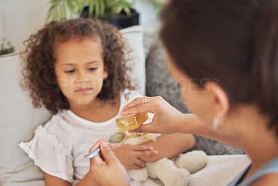 Buy stock photo Sick daughter taking medicine as a treatment, cure or remedy while lying on the sofa for health and recovery at home. Ill girl being given medication with a spoon by her loving and caring mother