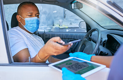 Buy stock photo Covid drive thru checkpoint man scanning QR code on a tablet with his phone traveling in a car. Man driving wearing a face mask at a coronavirus screening service using technology to send details 