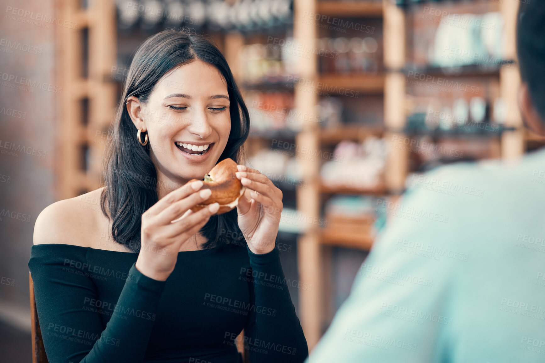 Buy stock photo Happy, beautiful and relaxed woman eating on a date at a restaurant with her partner on the weekend. Young and attractive female enjoying a meal or breakfast burger at a cafe with her boyfriend 