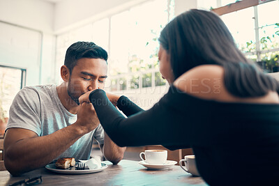 Buy stock photo Romantic, in love and affectionate dating couple together on a date at a cafe or restaurant. Lovely, caring and loving young boyfriend kissing and holding his girlfriend or lovers hands