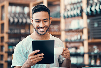 Buy stock photo Happy, relaxed and carefree man reading social media news on a tablet while enjoying coffee. Young casual guy replying to emails, browsing the internet or subscribing to online dating app at a cafe