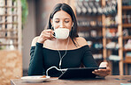 Beautiful, happy and relaxed student with tablet drinking coffee, listening to a podcast and music on earphones in a cafe. Woman online and watching distance learning education webinar in restaurant