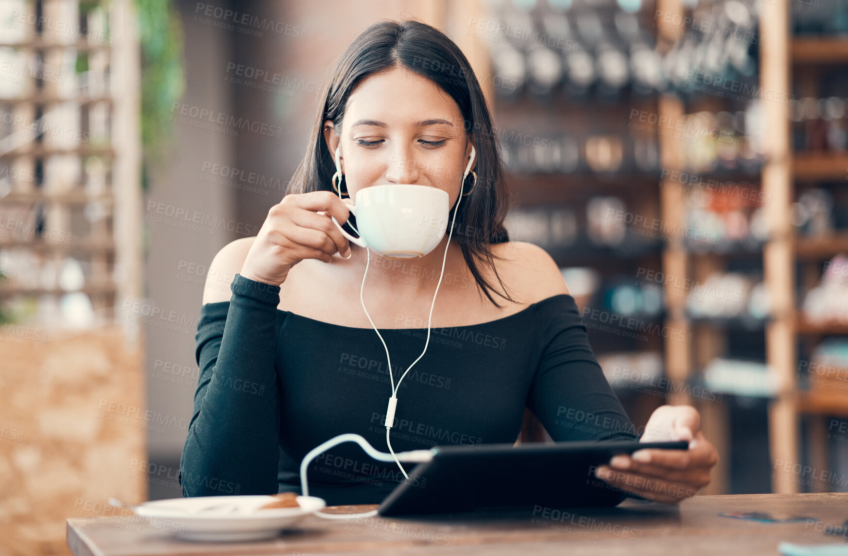 Buy stock photo Beautiful, happy and relaxed student with tablet drinking coffee, listening to a podcast and music on earphones in a cafe. Woman online and watching distance learning education webinar in restaurant