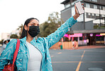 Trendy, stylish and funky student with phone travel app wearing covid mask and hailing, stopping and waving car, taxi and local transport or lift service. Cool, fashionable and careful woman in city