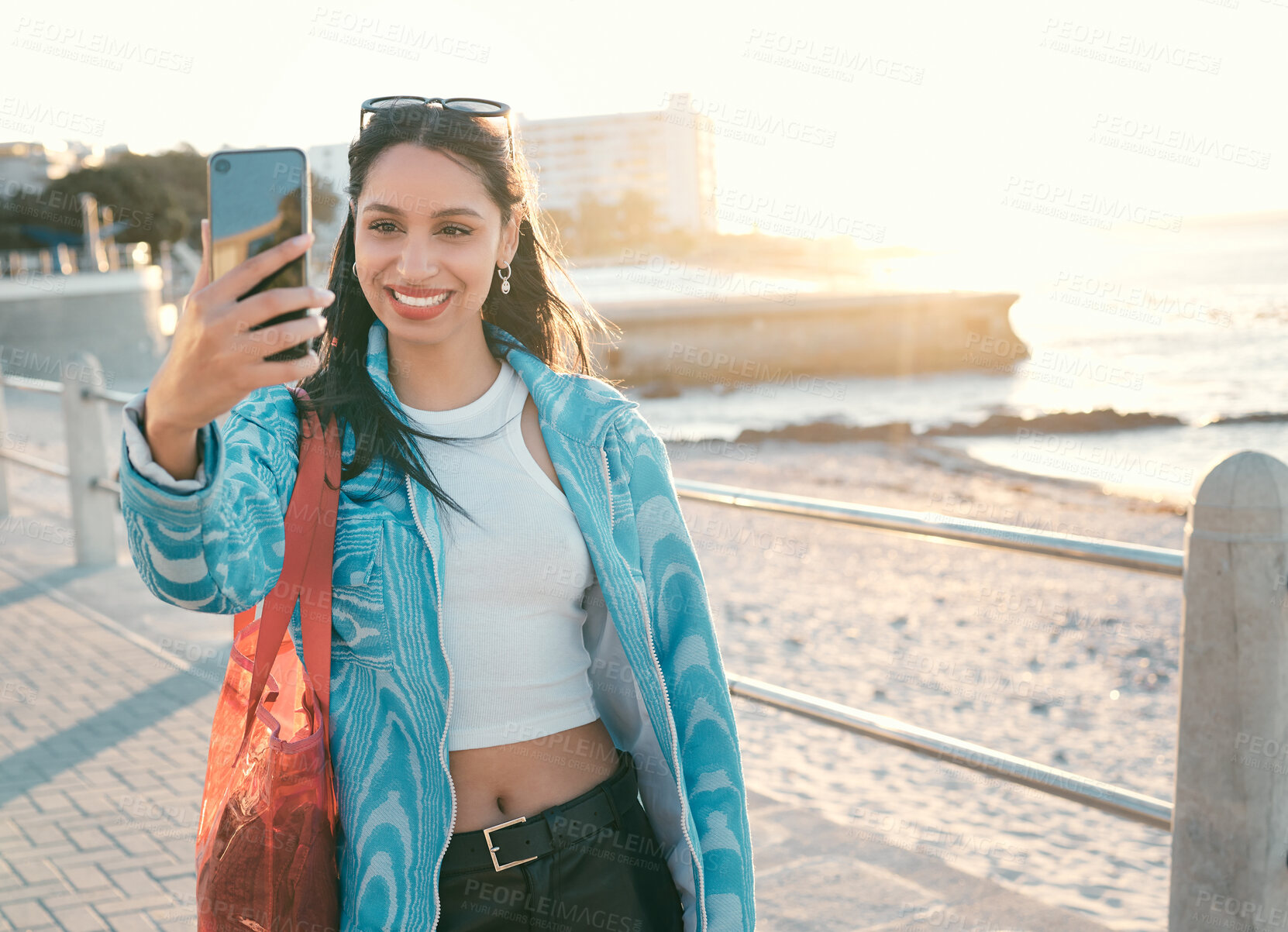 Buy stock photo Fun, happy and trendy student taking a selfie on phone for social media while exploring, visiting and enjoying city. Beautiful, young and smiling tourist taking photos on technology on vacation