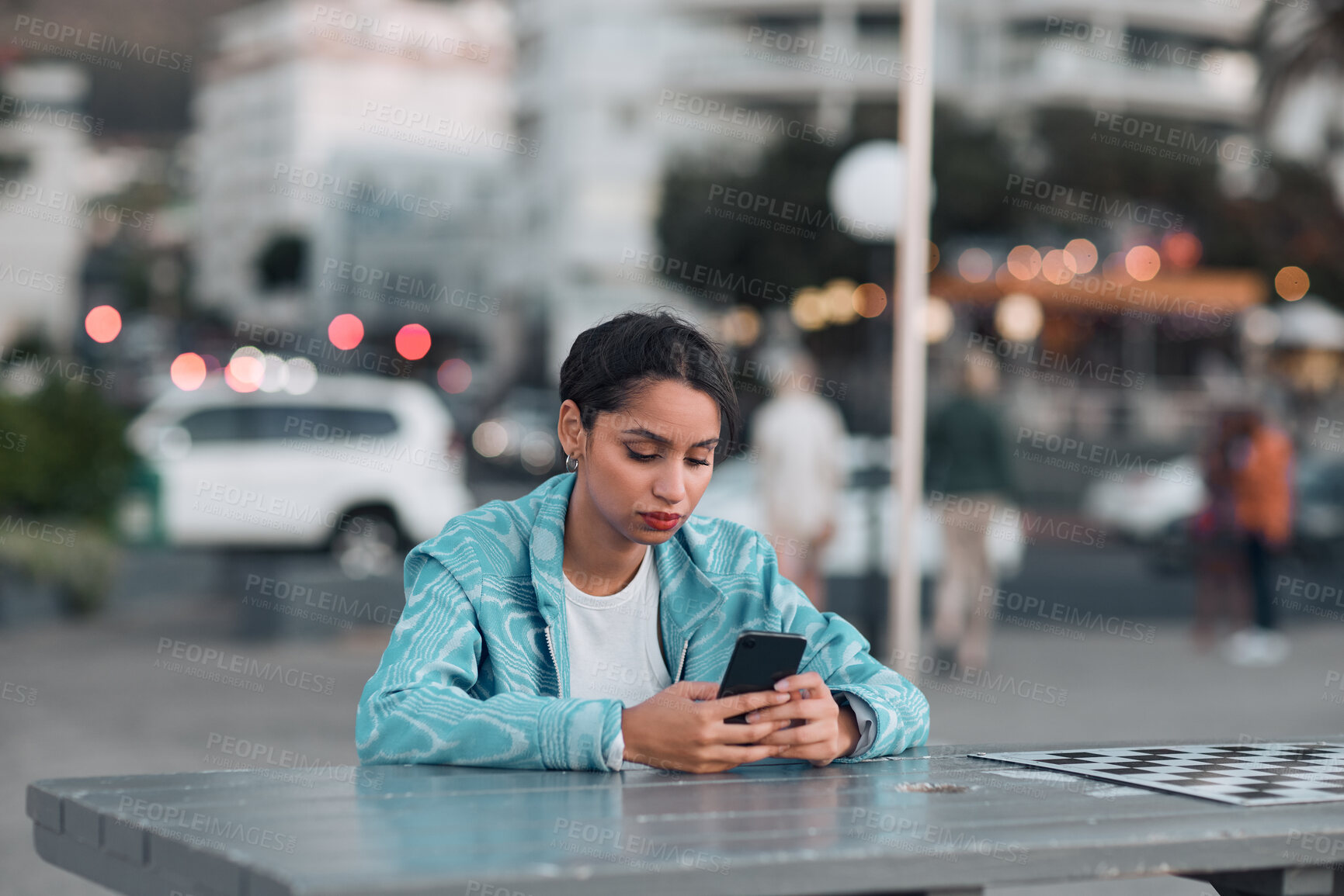 Buy stock photo Depressed, sad and bored woman with phone waiting and reading texts after being stood up on sunset city date. Annoyed, anti social and lonely student checking and browsing social media on technology