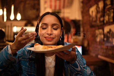 Buy stock photo Hungry woman with delicious pizza, food or consumables at a bar, restaurant or diner at night. One happy and casual girl, foodie or tourist enjoying a dinner meal at a local trendy location