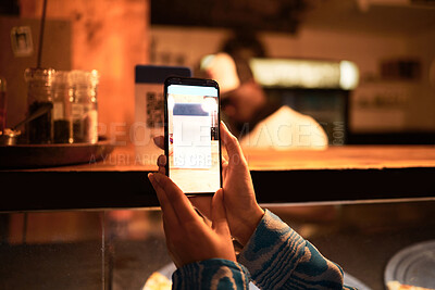 Person with phone camera scanning QR bar code for online menu at a modern restaurant, shop or cafe at night. Trendy woman taking photo scan to an instant website information the new normal lifestyle