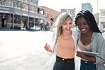 Laughing, happy and trendy students walking together in city after study session with tablet downtown. Stylish, cool and funky women and young friends bonding, embracing and hugging on a town street