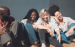 Happy, carefree and trendy friends laughing and talking while sitting in the sun together, enjoying their free time. Diverse group bonding, hanging out, relaxing, catching up and chilling on weekend