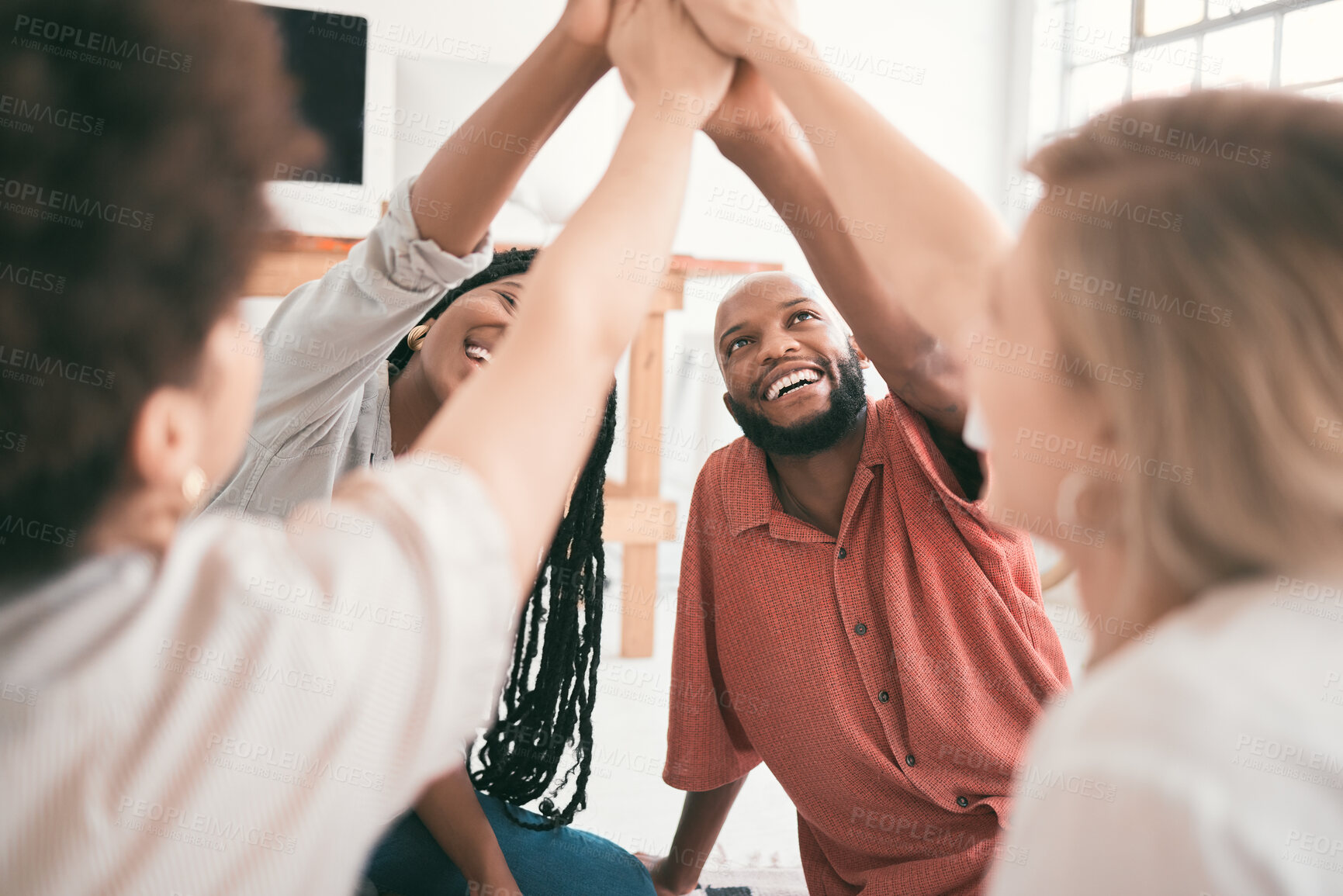 Buy stock photo Teamwork, unity and high five from young students having fun while sitting together in a room. Diverse friends showing support while being united and enjoying their study session or group project 