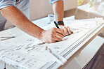 Male architect hands and arms drawing building project or construction plan at an office table. Closeup of caucasian man taking measurement notes, sketching and making corrections to a blueprint.