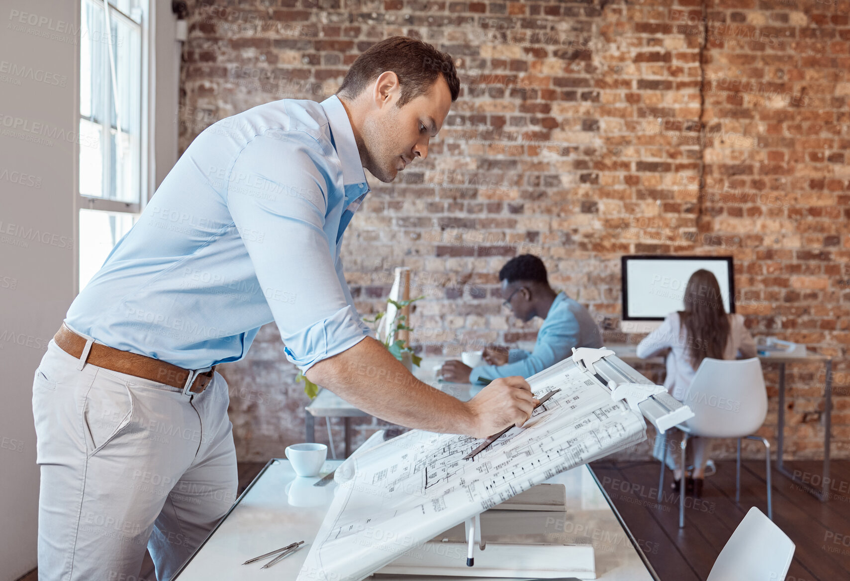 Buy stock photo Architect, design engineer or building contractor drawing a plan on a drafting table for a project or development in his office. A male designer doing a blueprint sketch at an architecture company