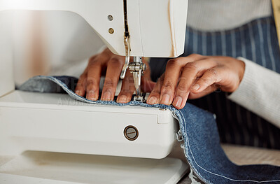 Buy stock photo Close up hands of a professional female designer sitting on a sewing machine in her studio. Process of a tailor at work on repairing and designing clothes. Casual alterations being done to jeans.