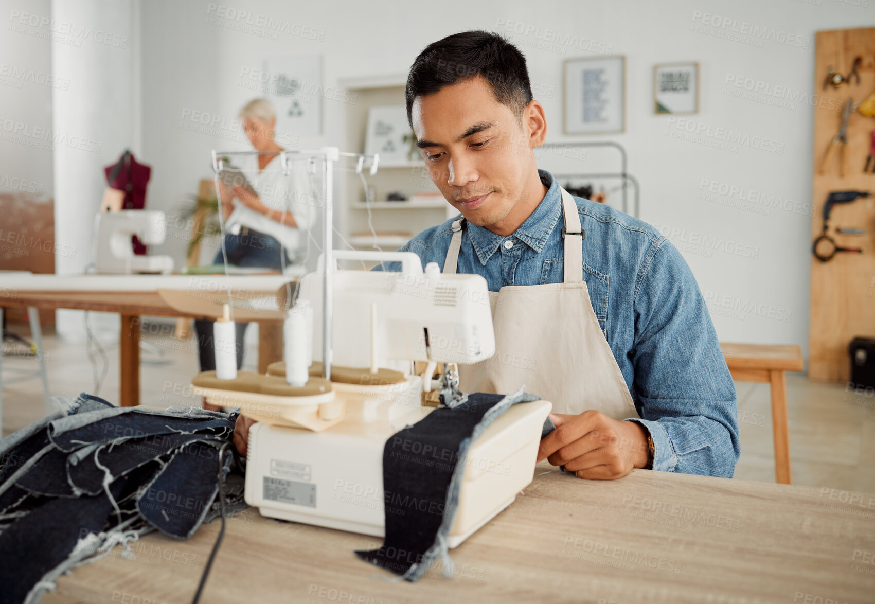 Buy stock photo Fashion, design and style with a young designer working in a startup on a sewing machine in a workshop. Busy and creative designer creating new, trendy and fashionable clothes in a small business