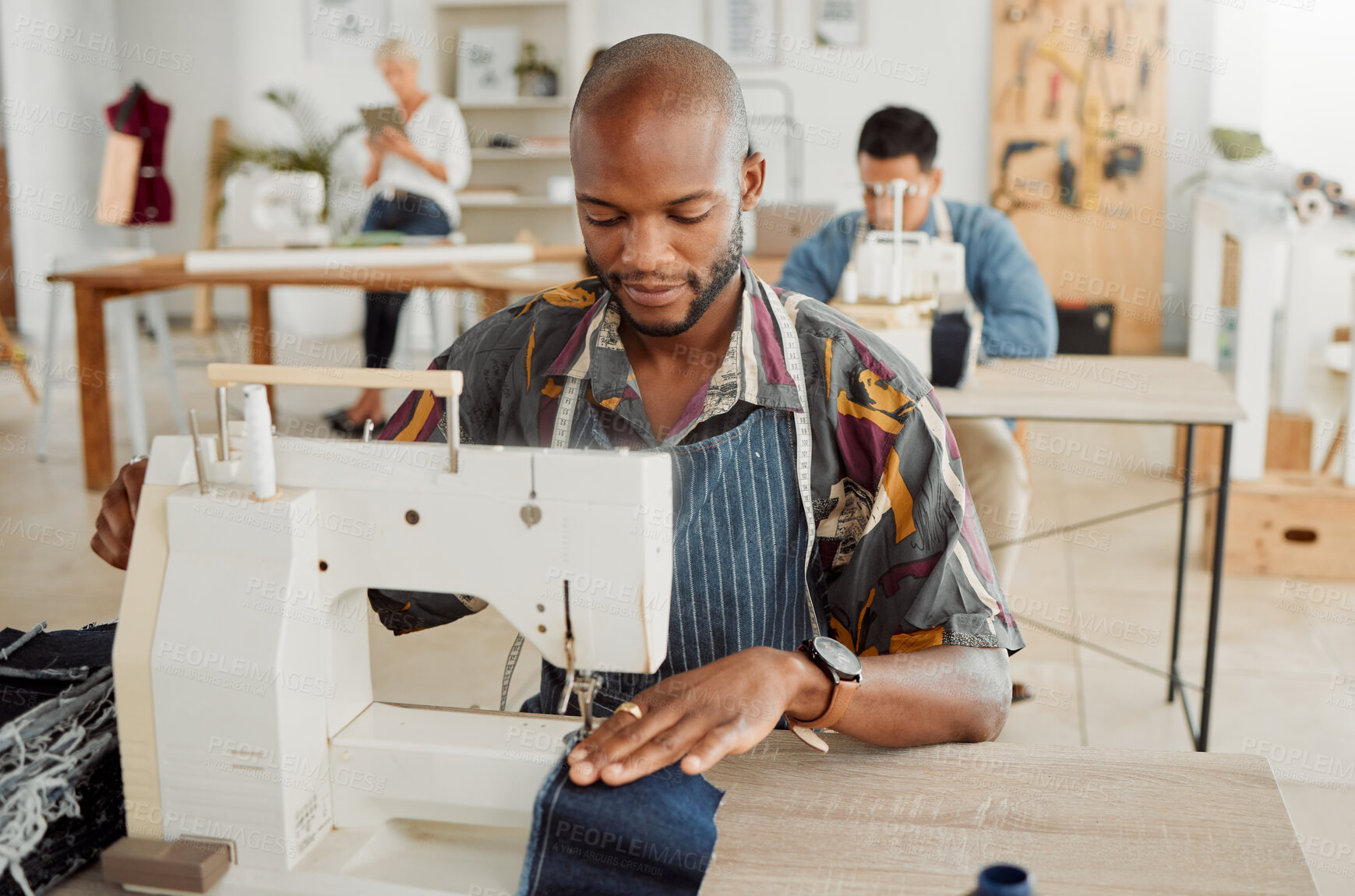 Buy stock photo Fashion designer, young man and creative student in a workshop to sew clothes and garments. Factory worker, tailor and apprentice learning sewing machine skills in a textile and manufacturing studio