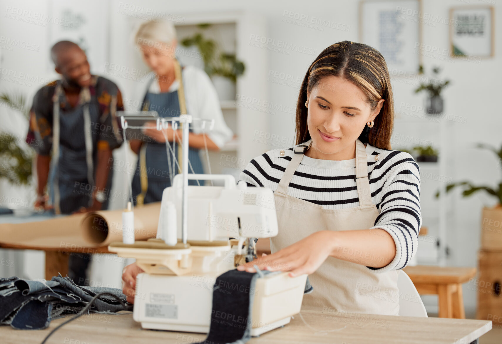 Buy stock photo Fashion, design and creative work in a textile workshop. Young female factory worker stitching trendy and stylish clothing in a startup. Busy tailor working on a sewing machine in a small business