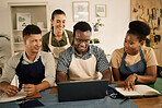 Fashion designers, colleagues and creatives browsing laptop while meeting to brainstorm a clothing range in a workshop. Team planning garment designs in a textile and manufacturing studio or factory