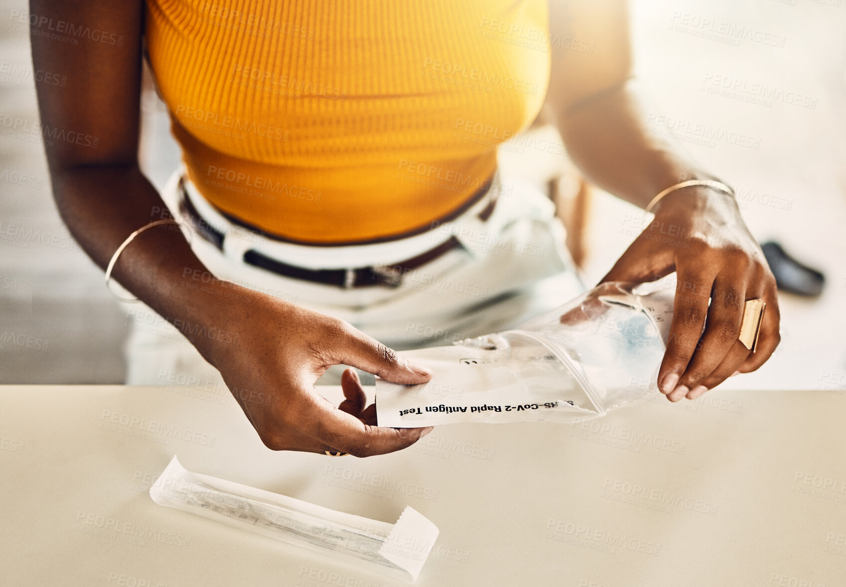 Buy stock photo Closeup of casual adult woman unpacking a covid test kit. Female preparing vaccine for corona testing for virus at home. Lady getting ready to self diagnose an illness, sickness or viral disease.