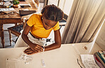 Black woman looking at time while waiting for results of a home test for illness, disease or virus during lockdown inside. Top view of female looking anxious, stressed and scared using a medical kit