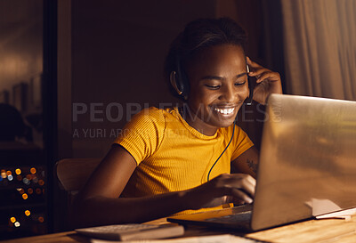 Young, happy and beautiful woman working while listening to music. Girl making work fun and joyful through entertainment late at night. Smiling, positive female on a laptop sitting at a desk at home.