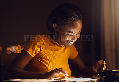 Happy, smiling and excited businesswoman shopping online on her tablet in the late evening at home. African American entrepreneur downloading and paying for apps. Modern living in the digital age
