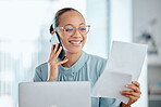 Happy business woman talking on a phone call, discussing contract with a client or colleague. Female executive holding and reading documents or paperwork, sitting in front of a laptop at office desk.
